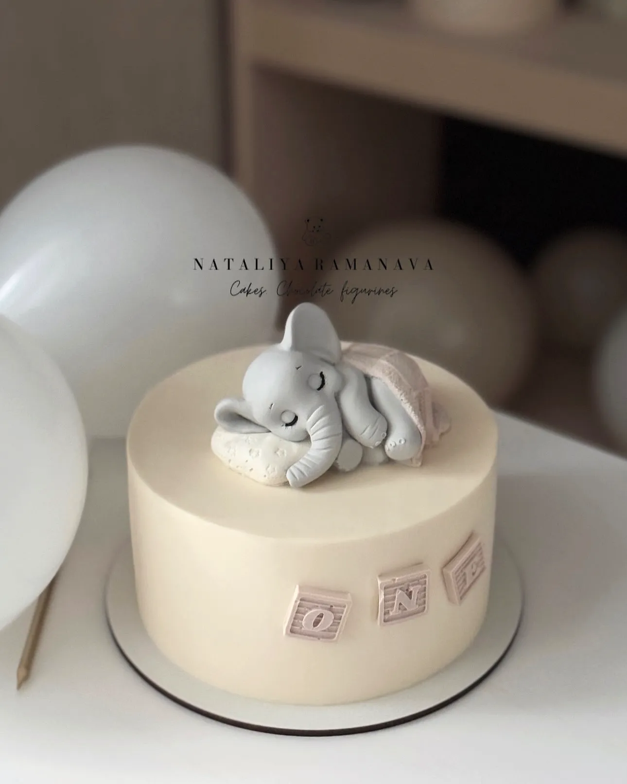 Adorable 1st Birthday Cake with Cute Sleeping Elephant and Playful Decor
