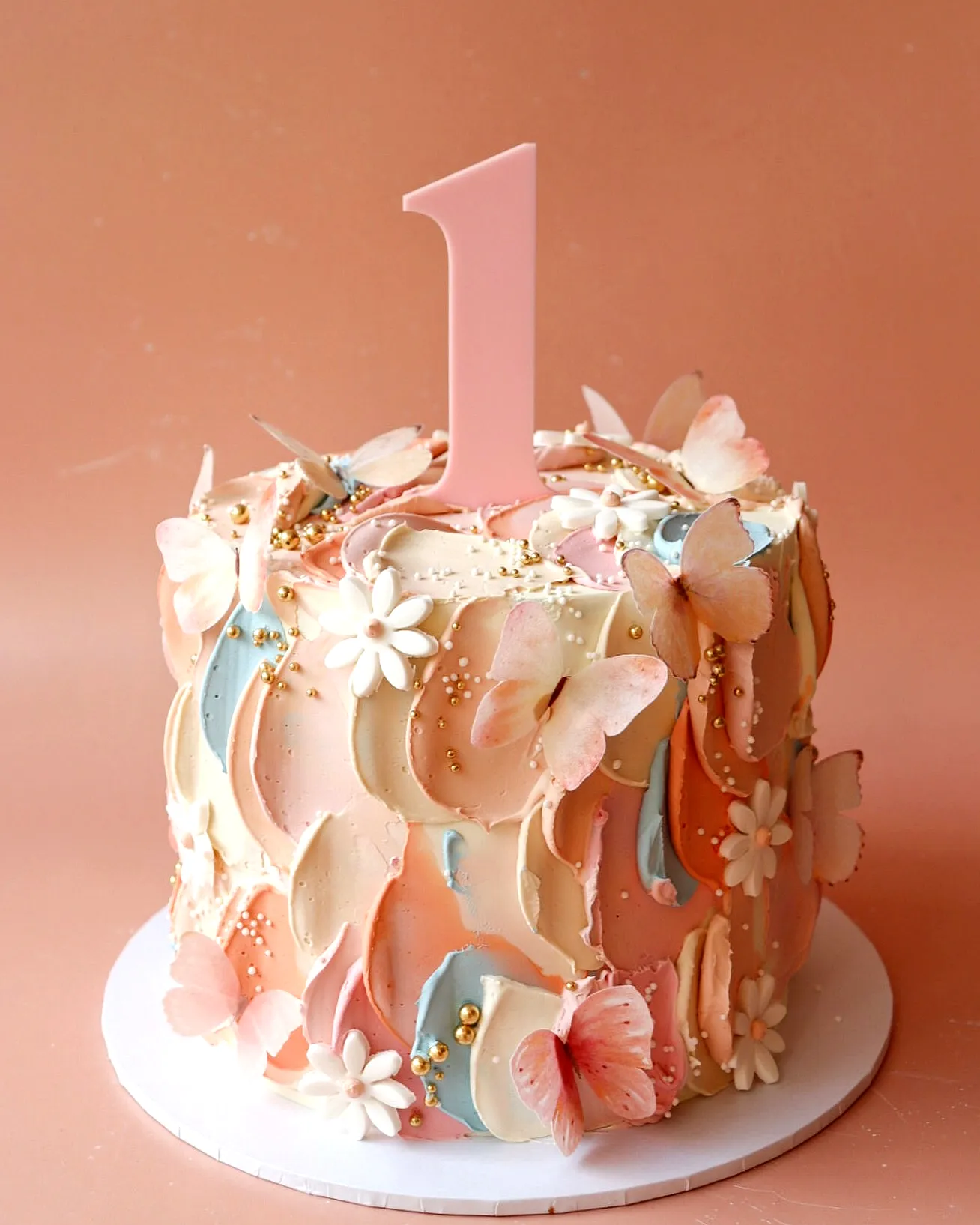 Adorable butterfly birthday cake design in soft pinks and creamy whites