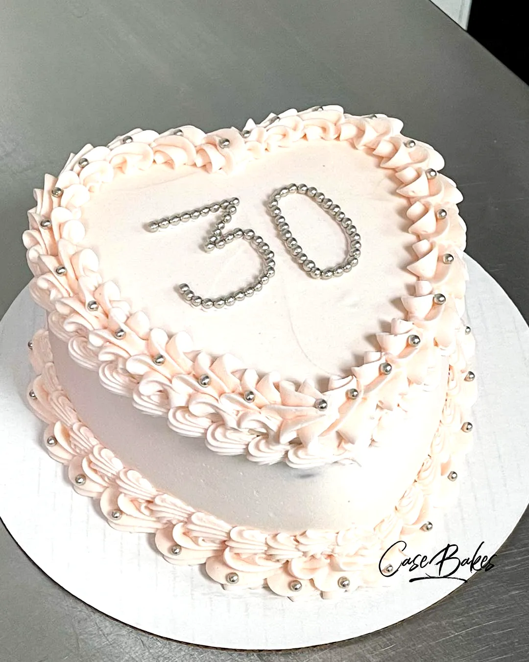 Adorable heart-shaped 30th birthday cake with elegant pink buttercream frosting