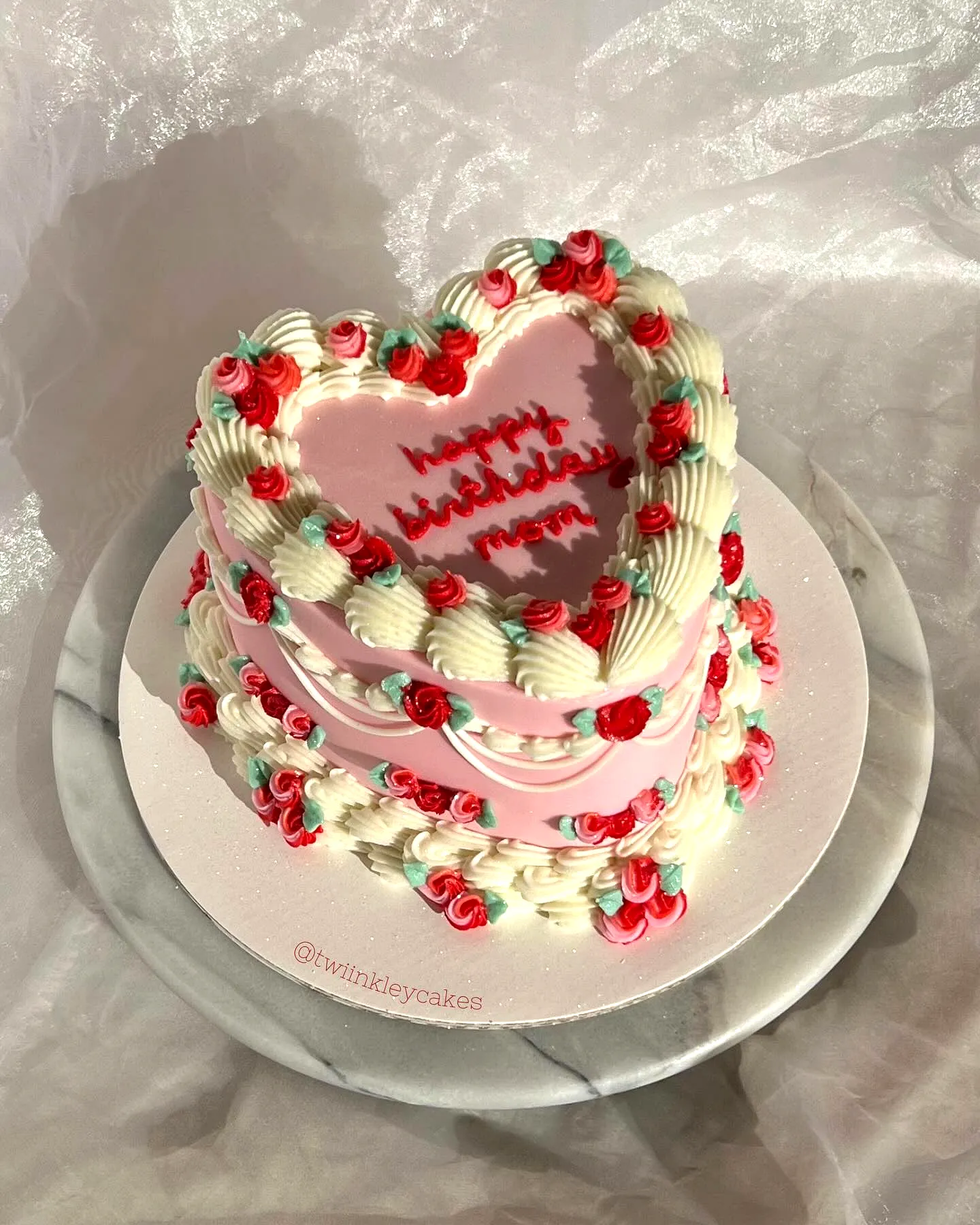 Adorable heart-shaped birthday cake for mom with pink frosting and vibrant decor