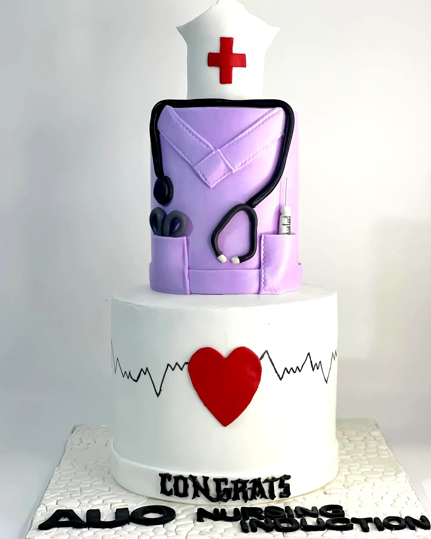 Adorable nurse graduation cake design with scrubs and stethoscope decorations