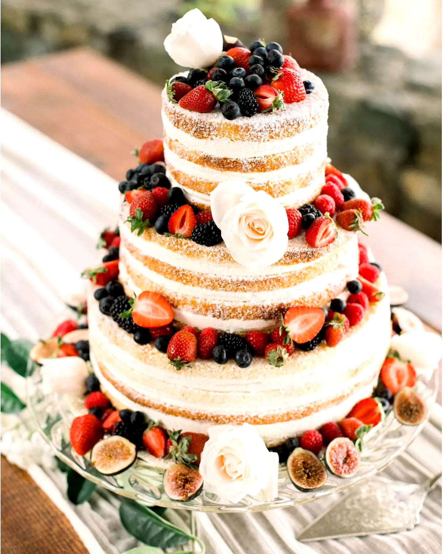 Adorable summer wedding cake with fresh berries and elegant roses