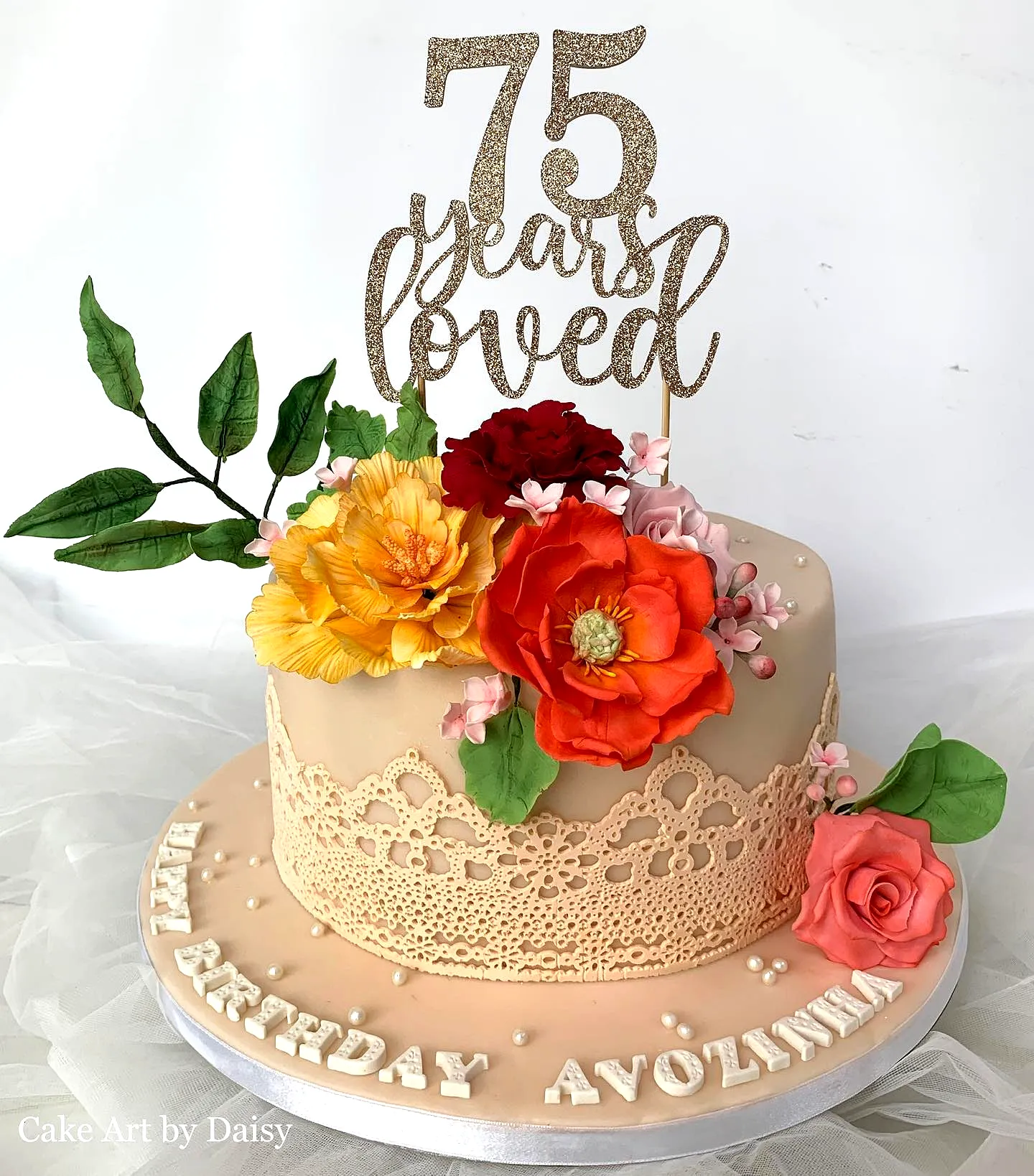Charming 75th birthday cake with vibrant flowers and elegant lace design