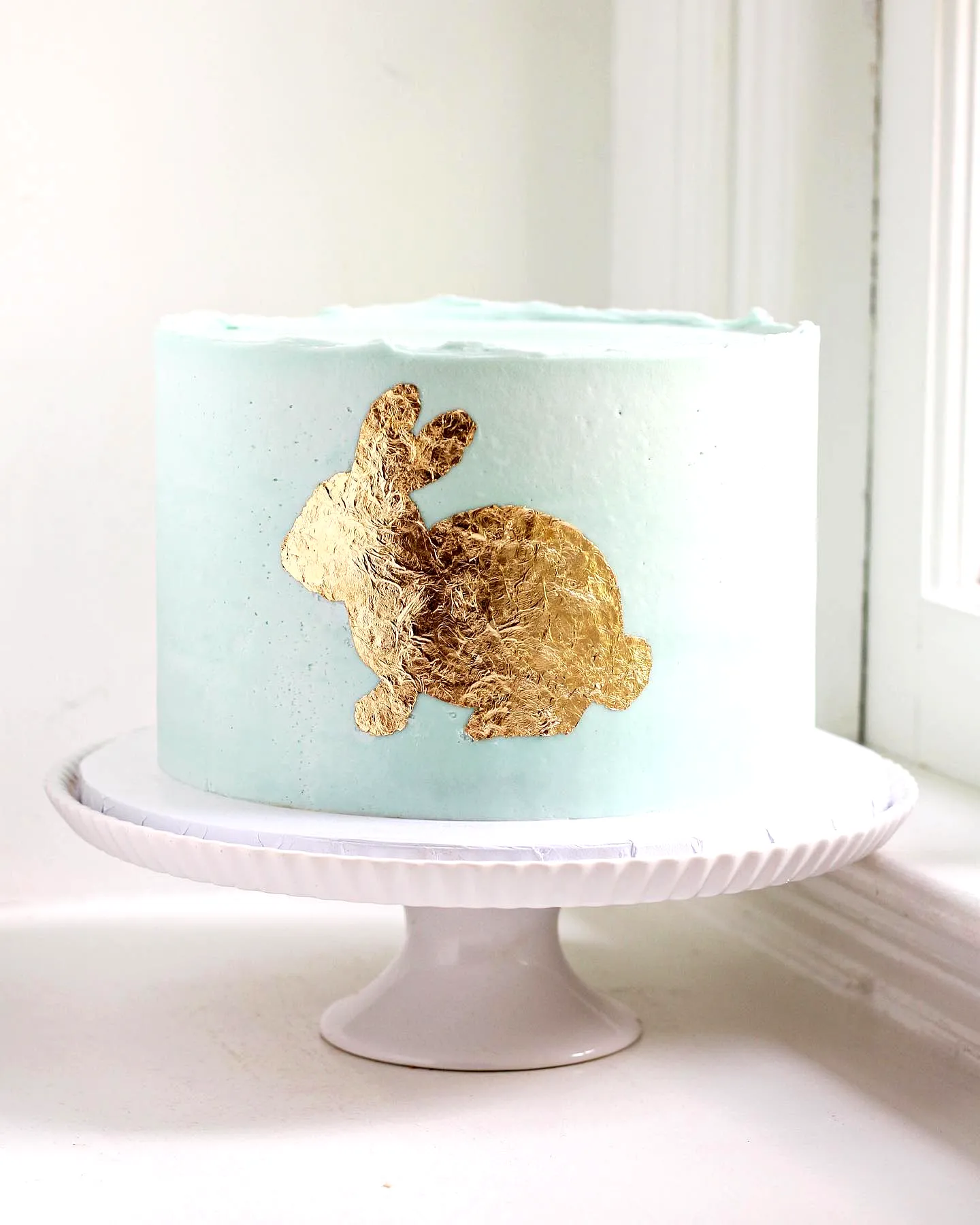 Charming Buttercream Easter Cake Design with Mint Green Frosting and Gold Rabbit