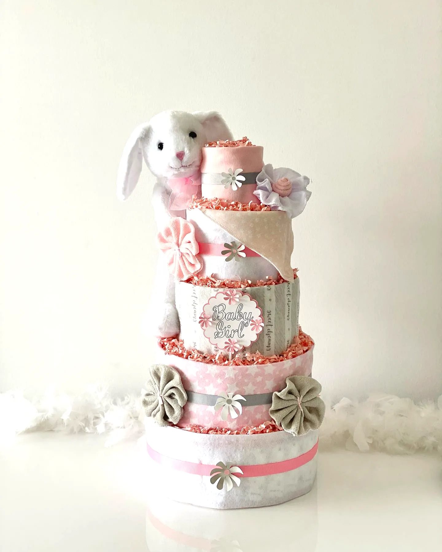Charming Diaper Cake Design in Pastel Pink and Gray with Whimsical Touches
