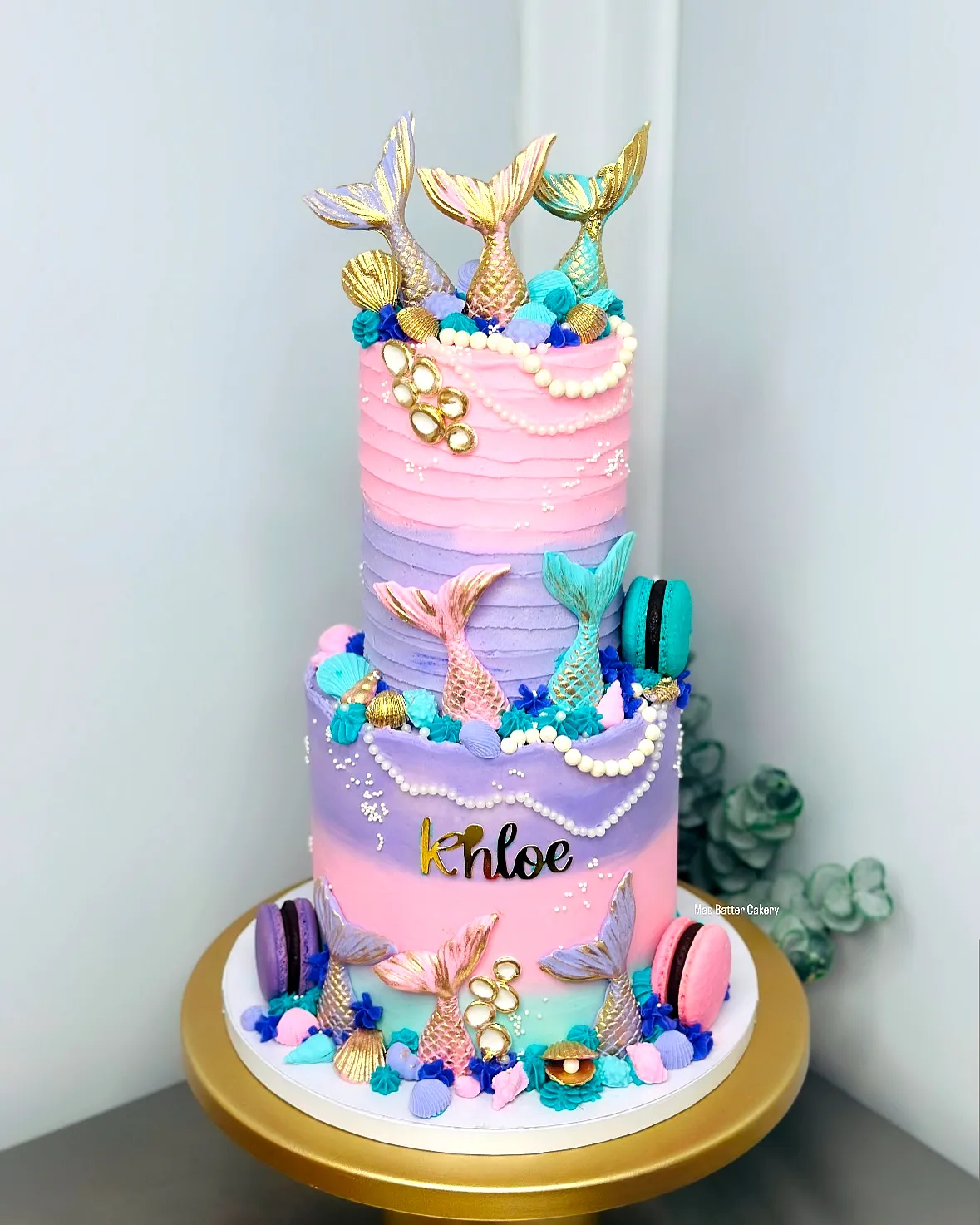 Charming mermaid birthday cake design with pastel swirls and gold accents
