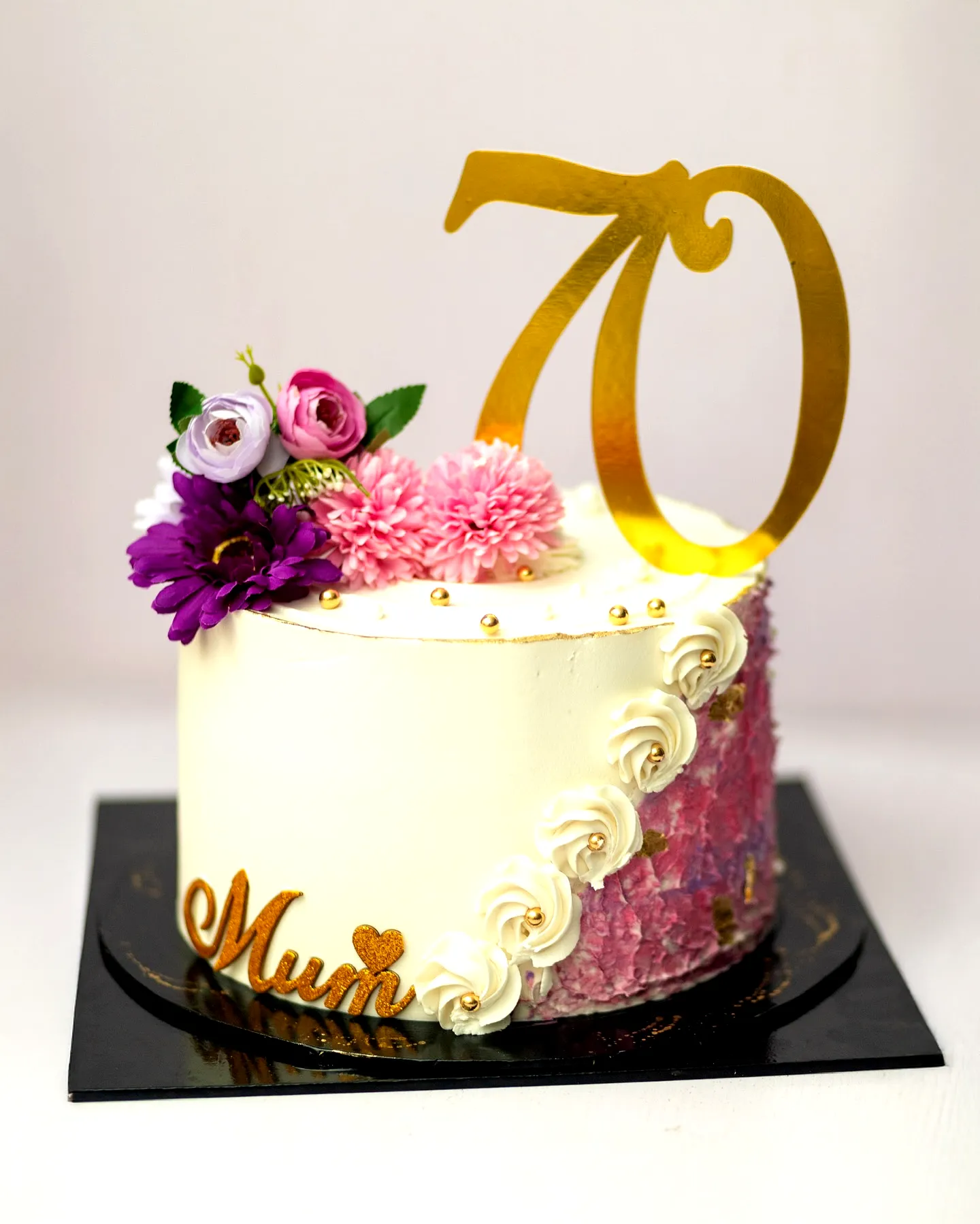 Colorful 70th Birthday Cake Design with Elegant Buttercream and Floral Accents