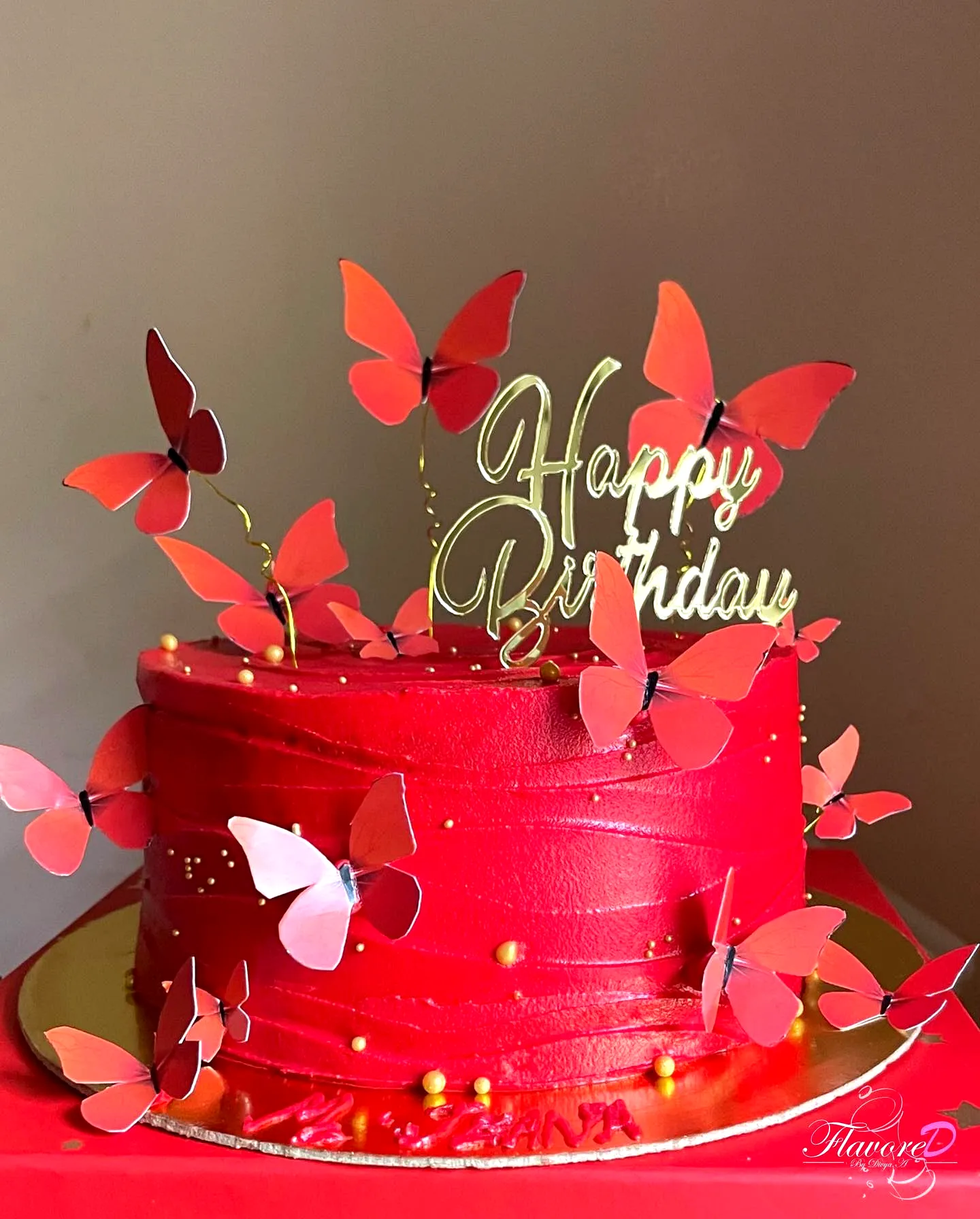 Colorful butterfly birthday cake design with smooth red buttercream finish