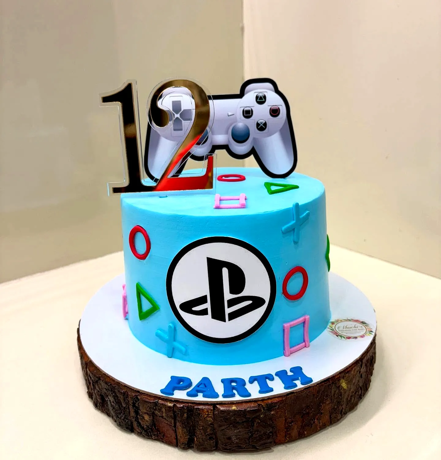 Creative gamer birthday cake design with PlayStation elements and vibrant colors