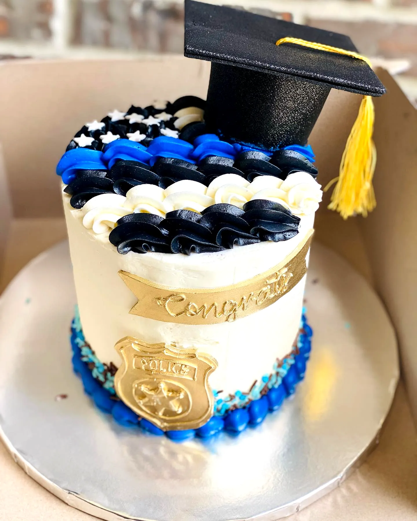 Creative police academy graduation cake design in sleek blue and black style