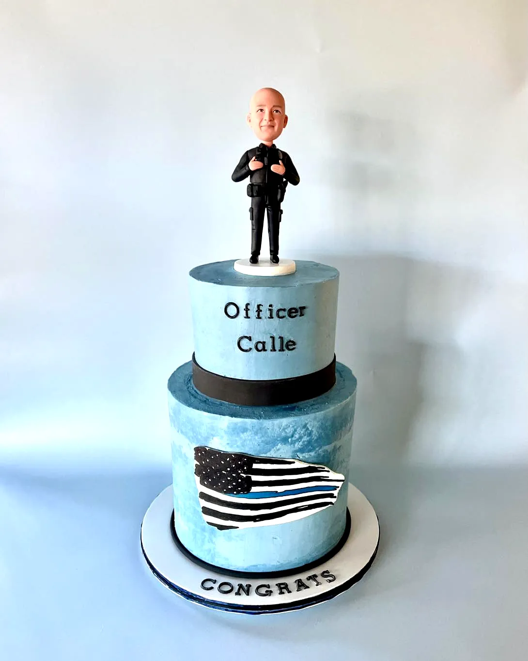 Creative police academy graduation cake design with blue ombre and figurine