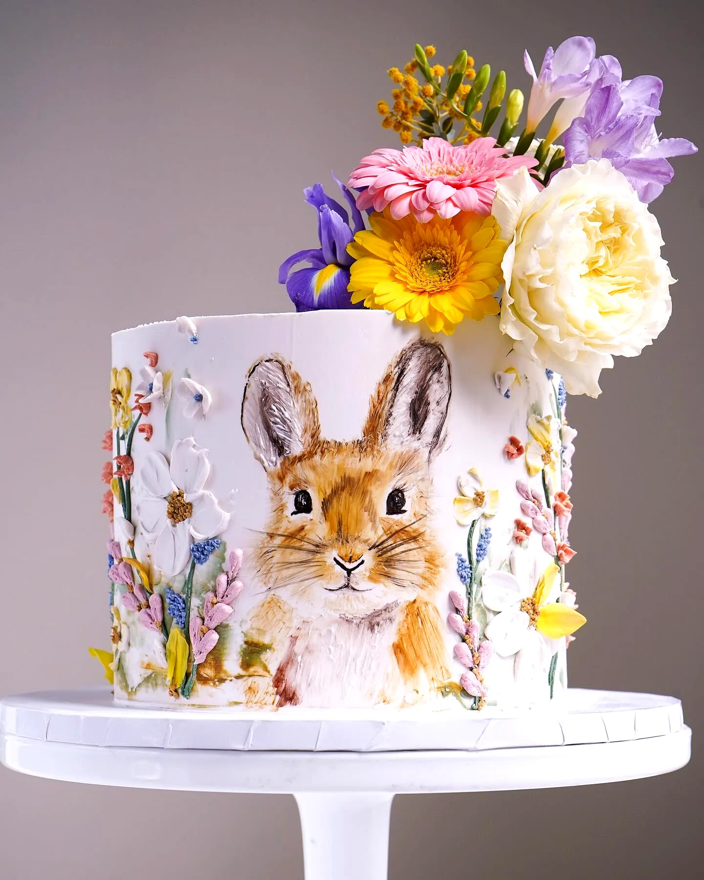 Cute bunny cake design with vibrant colors and whimsical floral decorations
