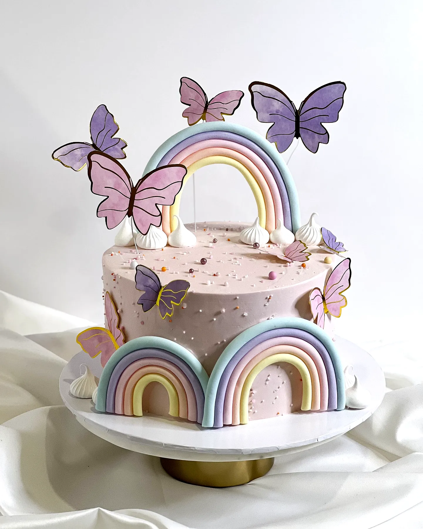 Cute butterfly birthday cake design with colorful decorations and soft pink frosting