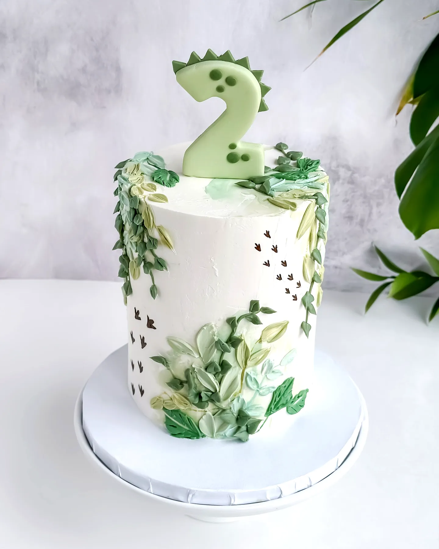Cute dinosaur birthday cake design with whimsical nature-themed decorations