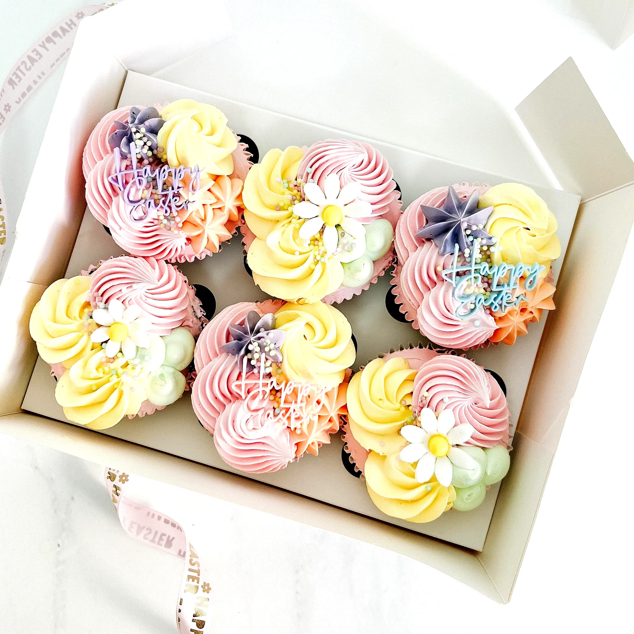 Cute Easter cupcake cake with pastel swirls and floral decorations