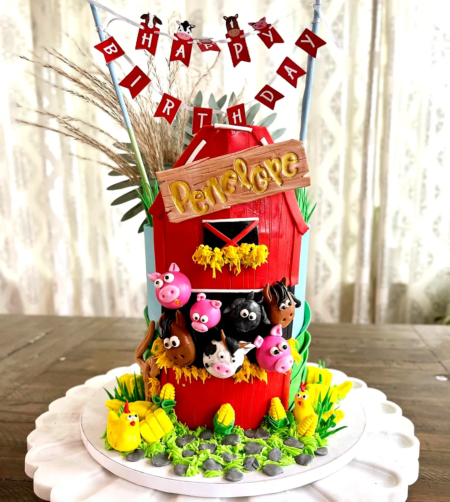 Cute farming birthday cake design with charming barn and playful animals