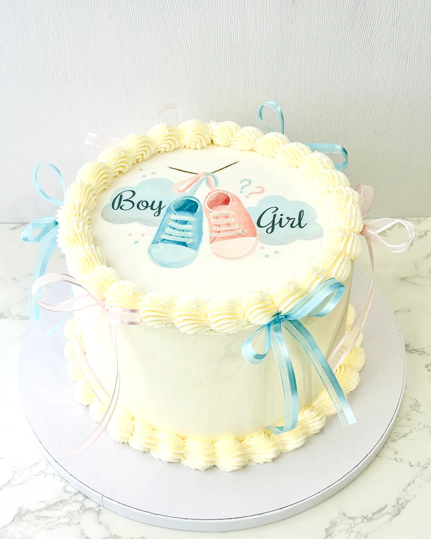 Cute gender reveal cake design with pastel colors and playful decorations