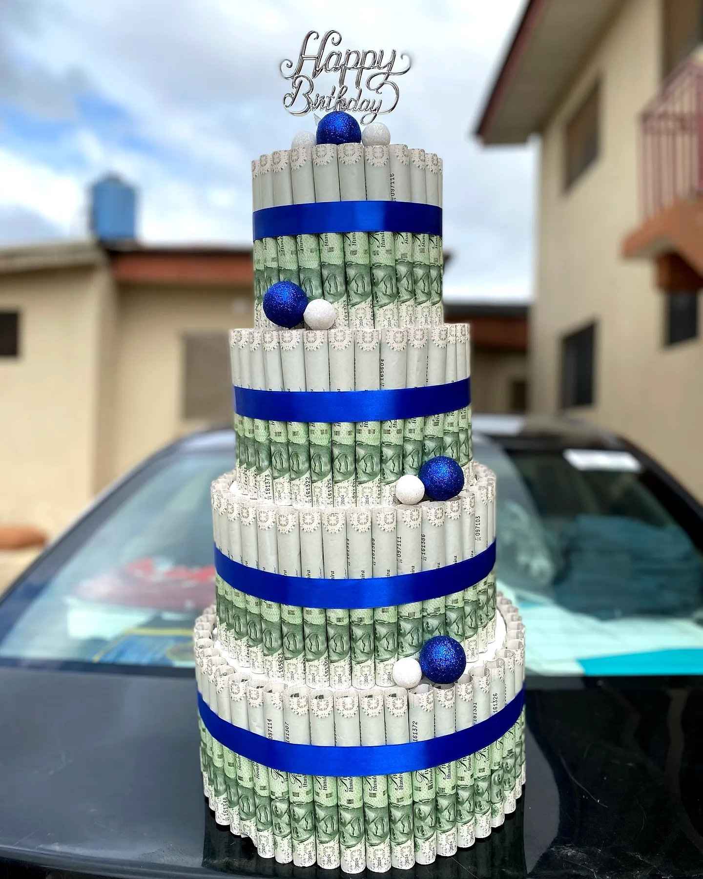 Cute graduation money cake design with blue and white decorative accents