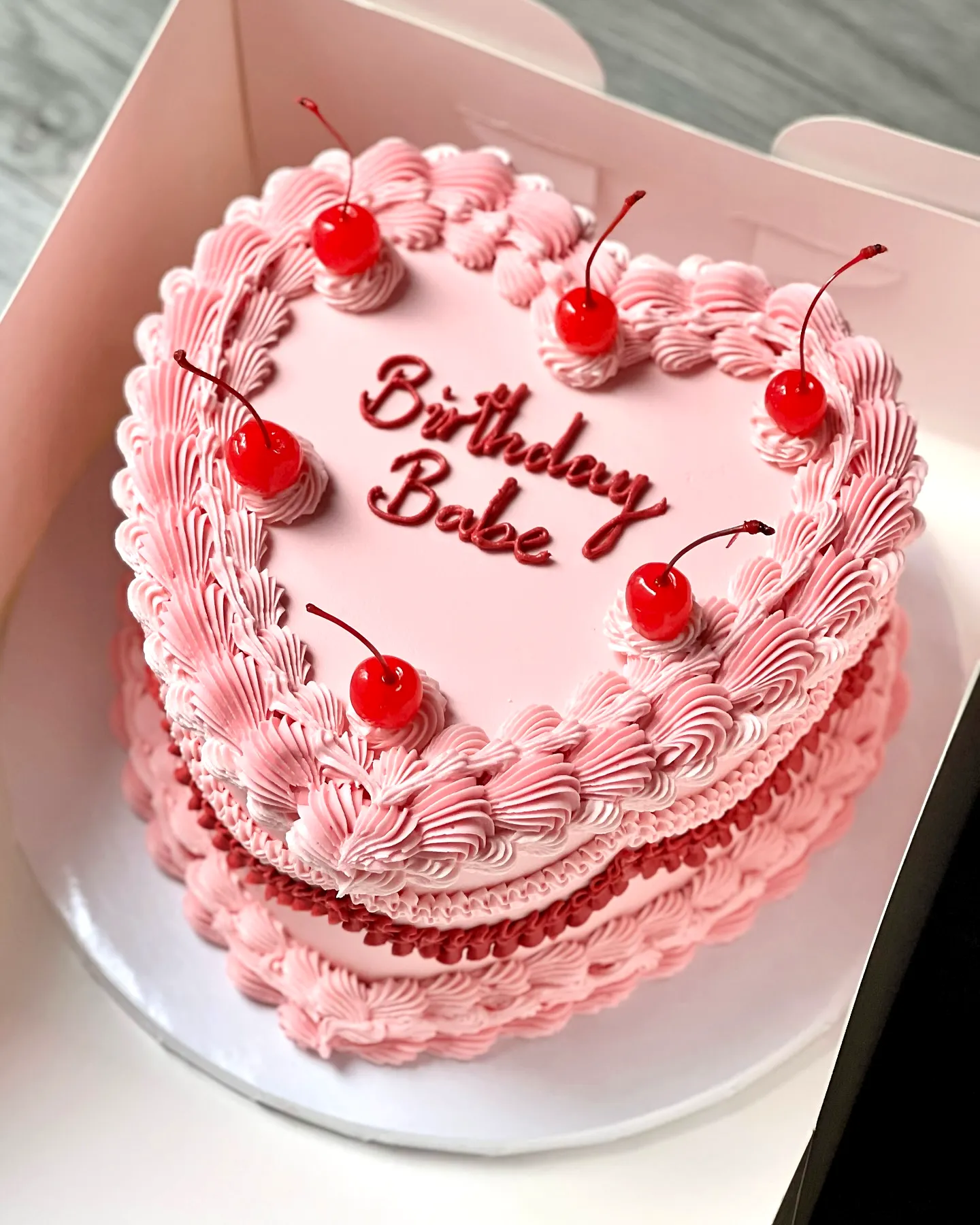 Cute Heart-Shaped Birthday Cake with Pink Frosting and Cherry Topping