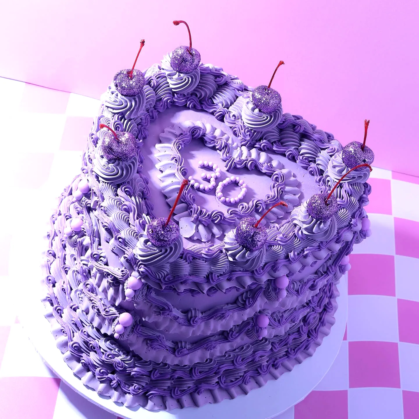 Cute heart-shaped purple birthday cake design with vibrant frosting and cherries