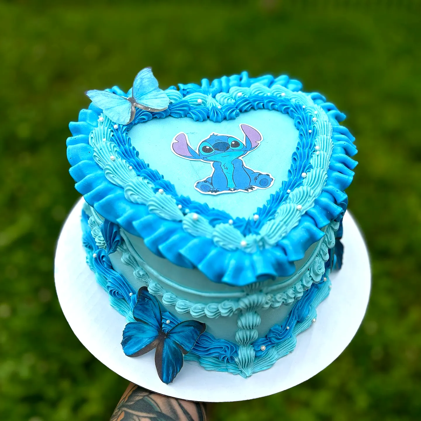 Cute heart-shaped stitch cake design in vibrant blue with whimsical decorations
