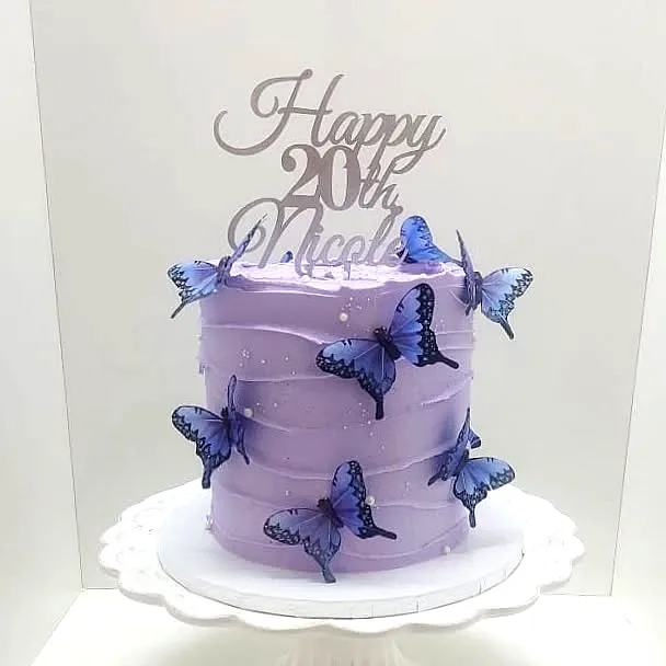 Cute lavender 20th birthday cake with blue butterflies and shiny topper