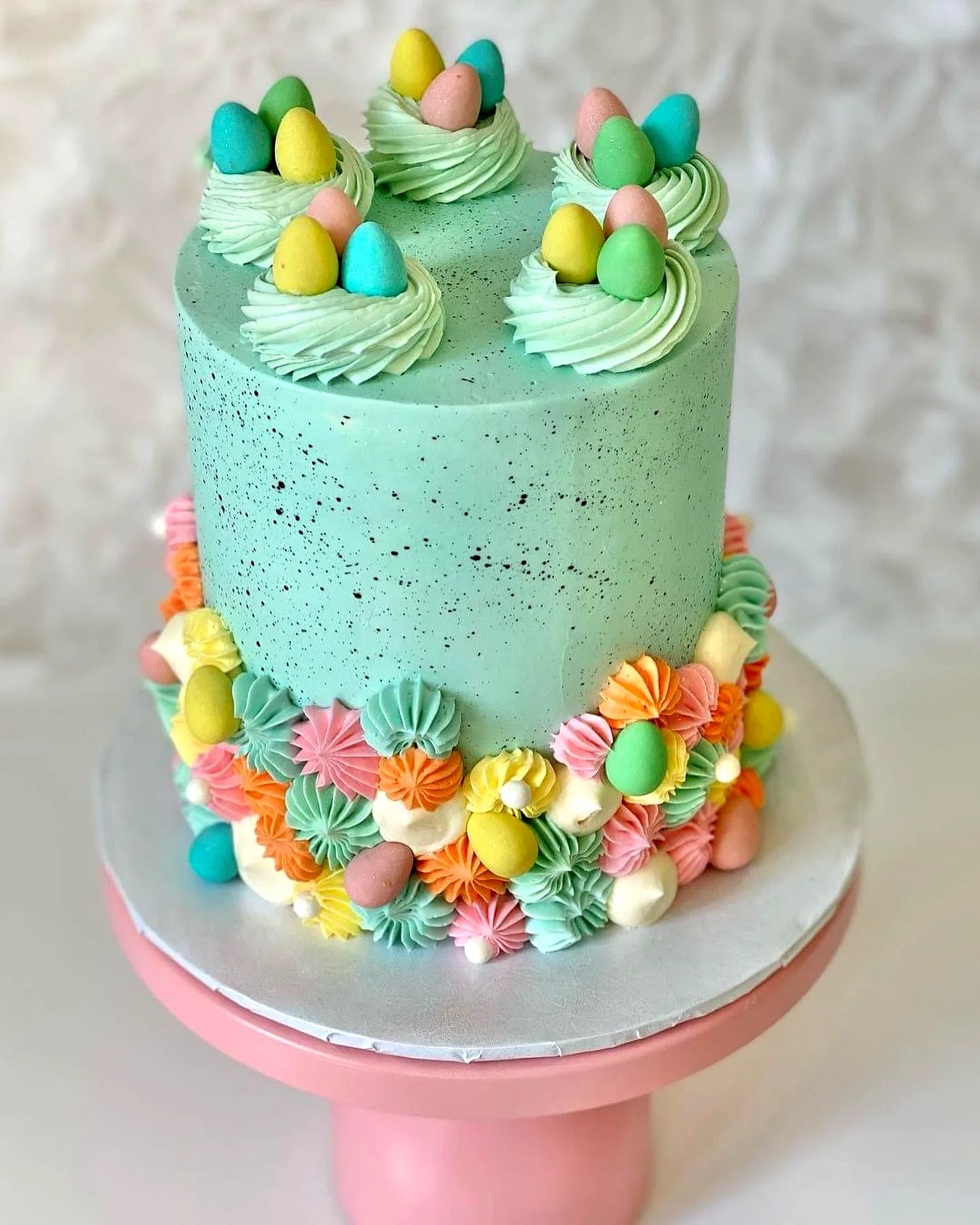 Cute mint-green buttercream Easter cake design with playful decorations