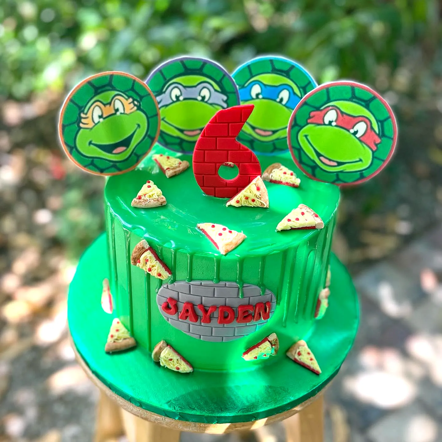 Cute Ninja Turtle Birthday Cake Design with Colorful Toppers and Pizza Decor