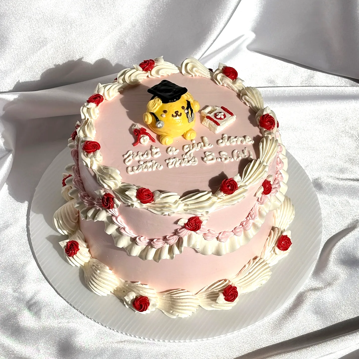 Cute nurse graduation cake design with soft pink and cheerful decorations