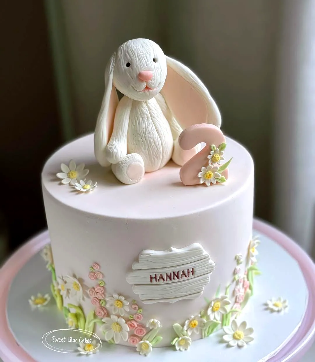 Cute pink Easter cake decorating ideas with floral accents and a bunny topper