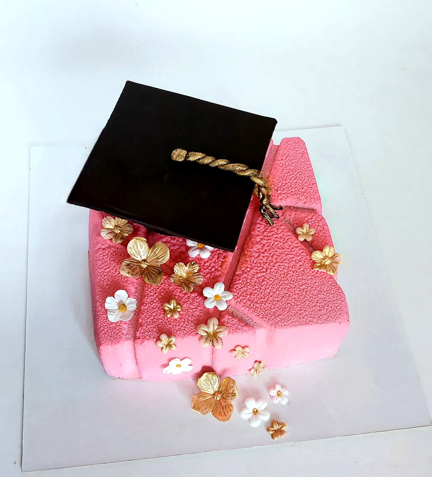 Cute pink graduation cake design with elegant decorations and fondant texture