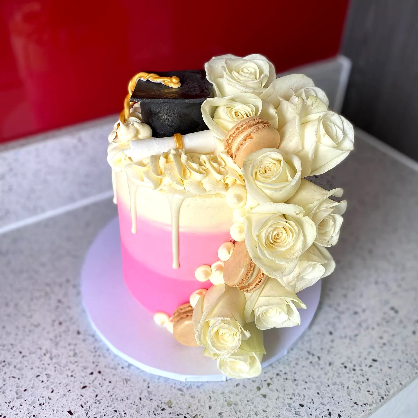 Cute pink graduation cake design with ombre frosting and elegant decorations
