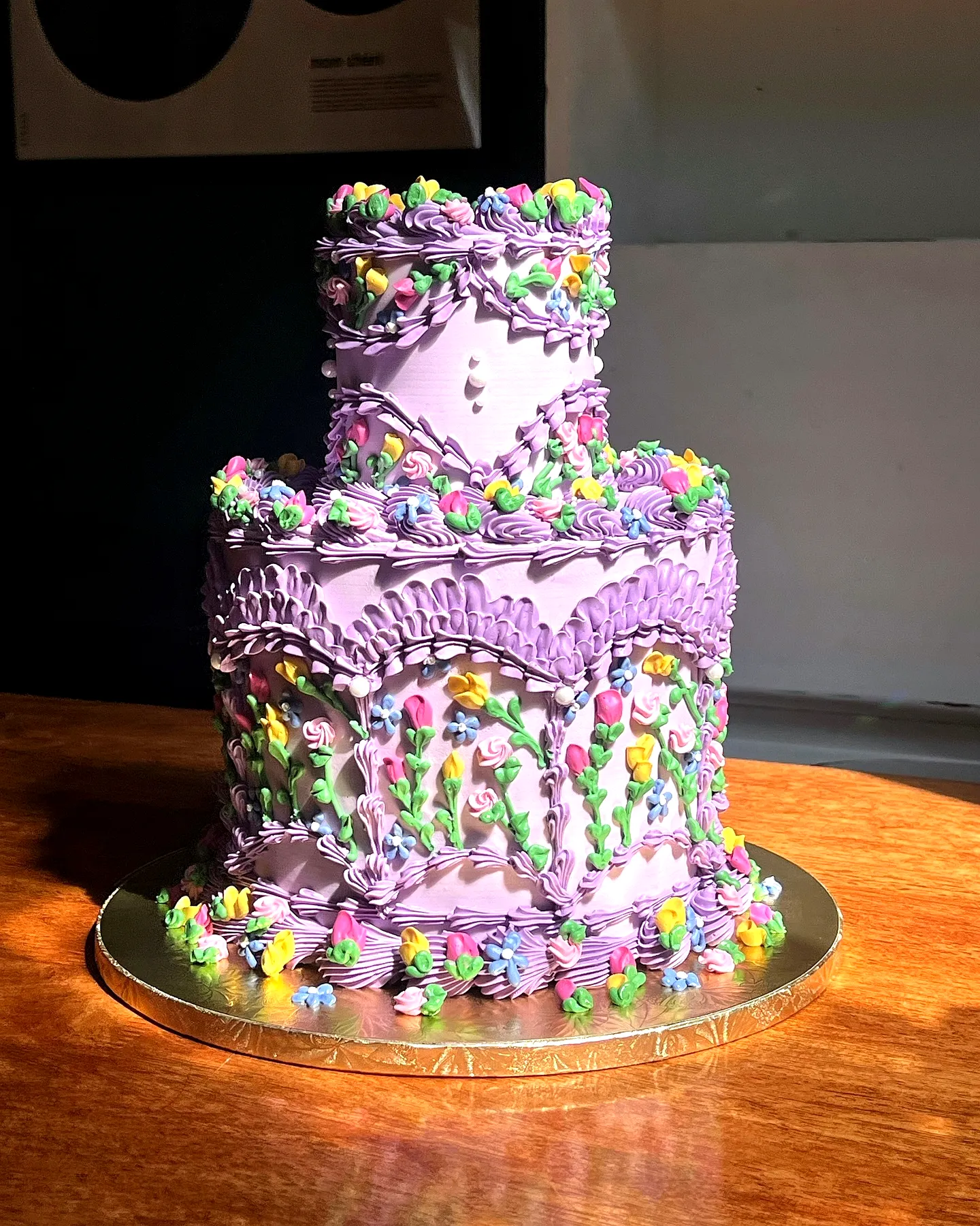 Cute purple birthday cake design with whimsical floral patterns and swirls