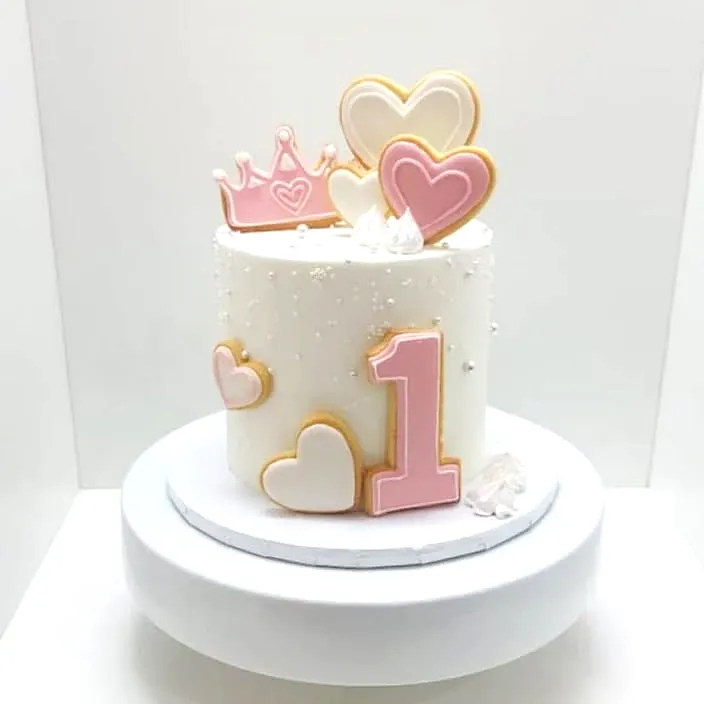 Cute Round Vanilla Cake for 1st Birthday Celebration with Heart Cookies