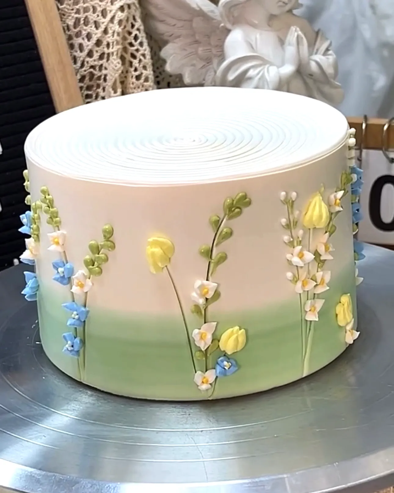 Cute sage green birthday cake design with delicate floral decorations
