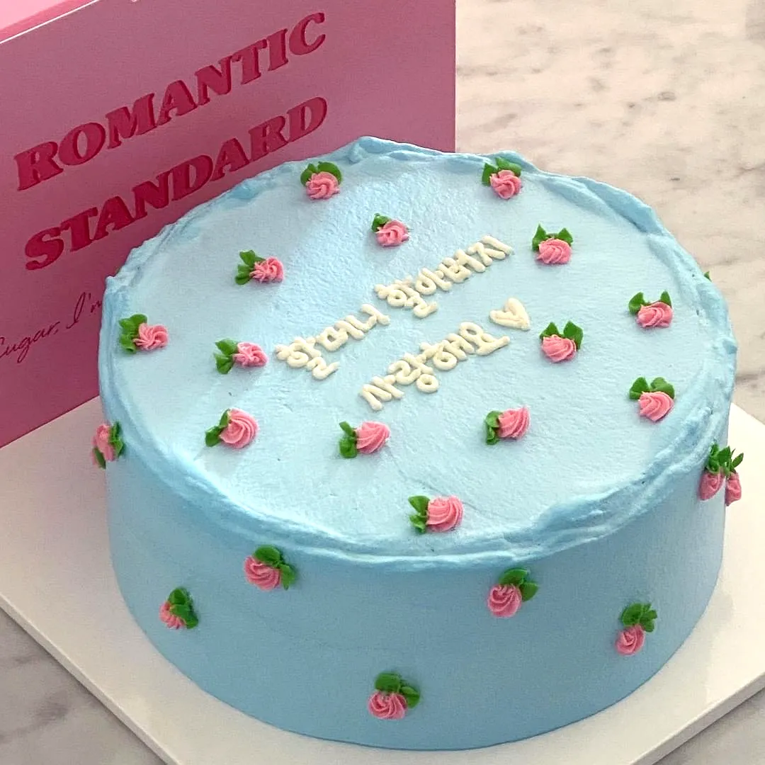 Cute simple birthday cake design with lovely light blue frosting and floral decor