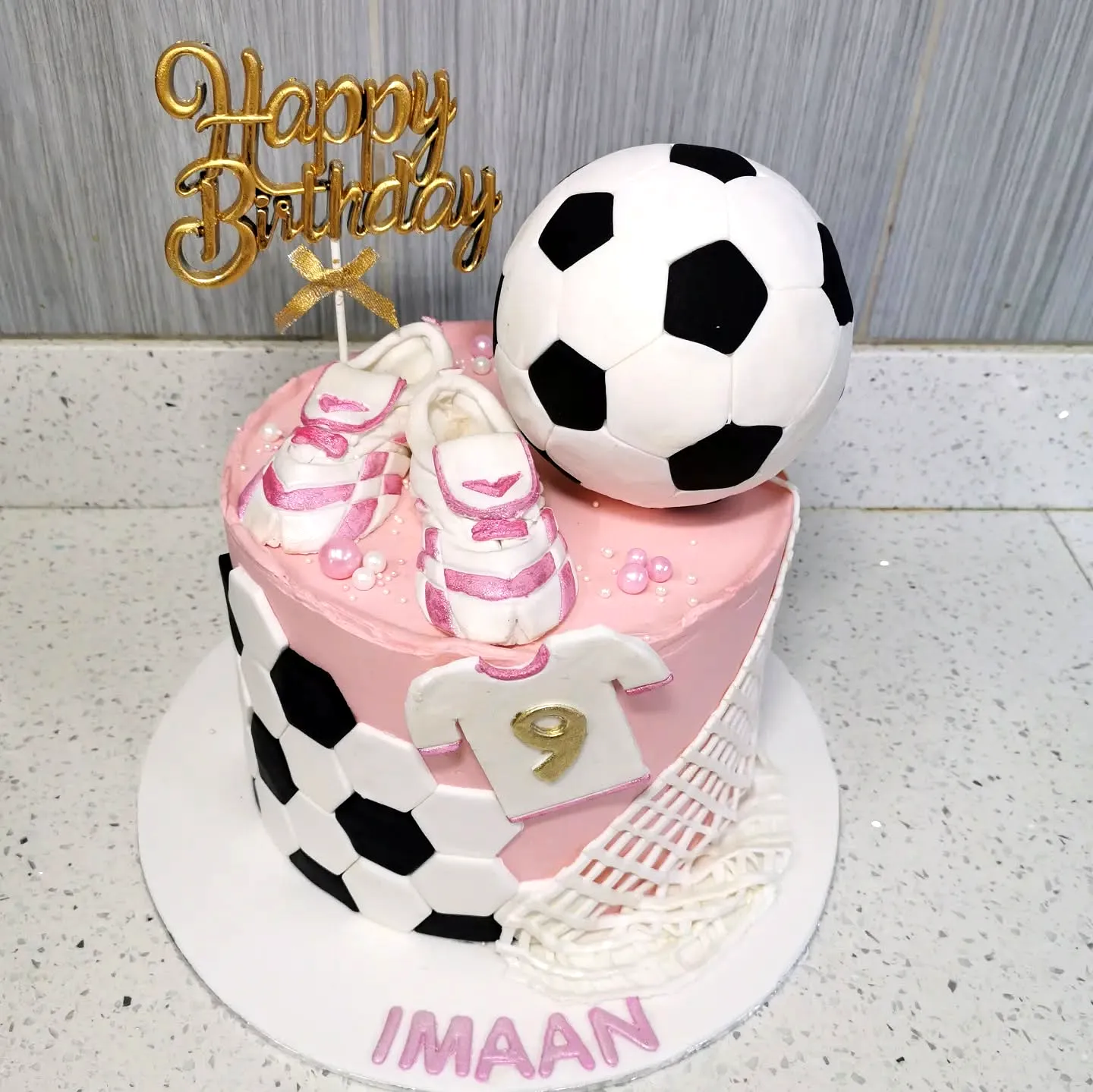 Cute soccer birthday cake design in vibrant pink and black colors