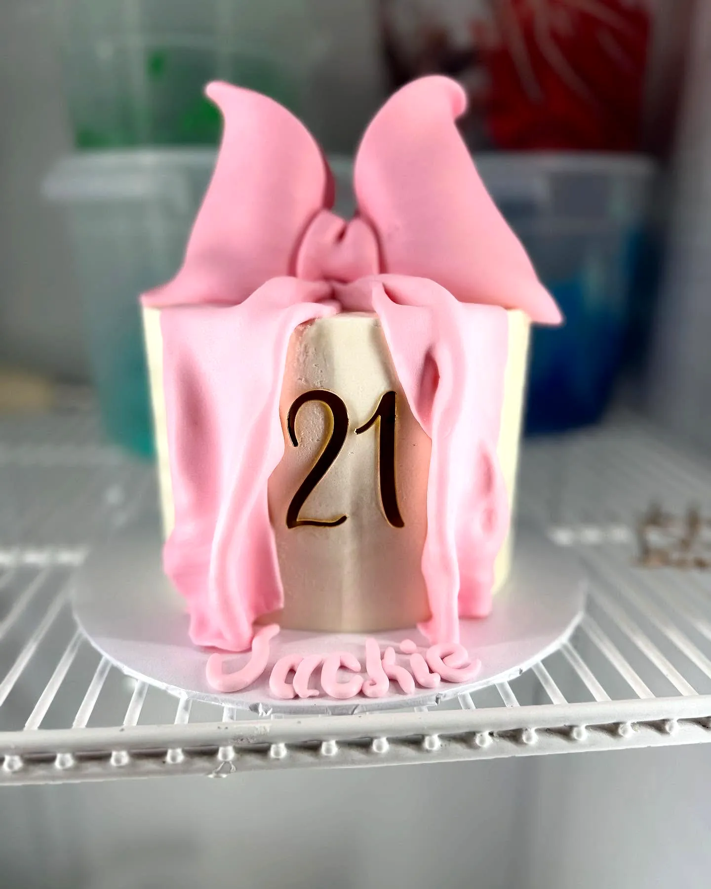 Cute two-tiered 21st birthday cake with chic pink fondant drape