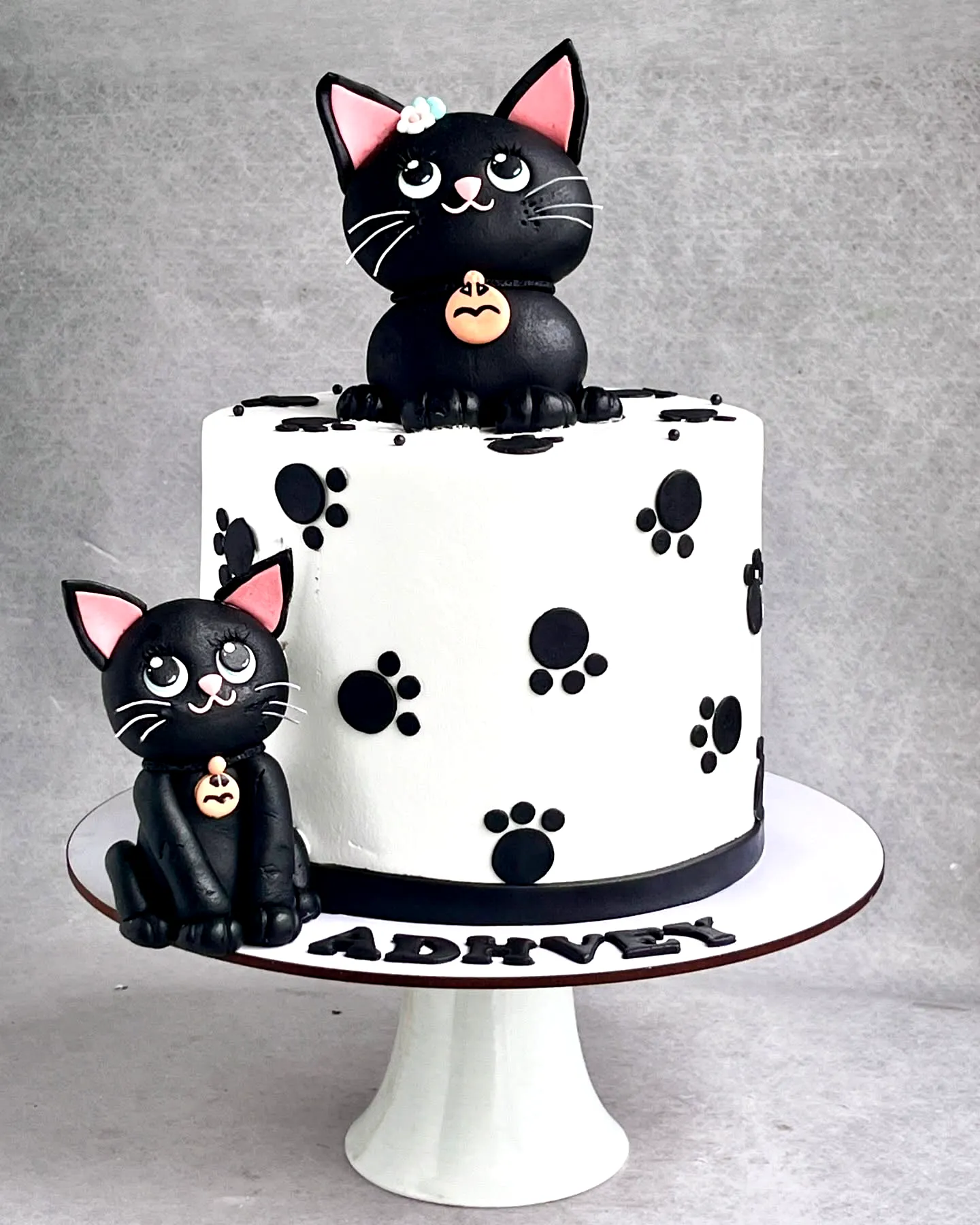 Cute Two-Tiered Cat Birthday Cake Design with Playful Paw Prints
