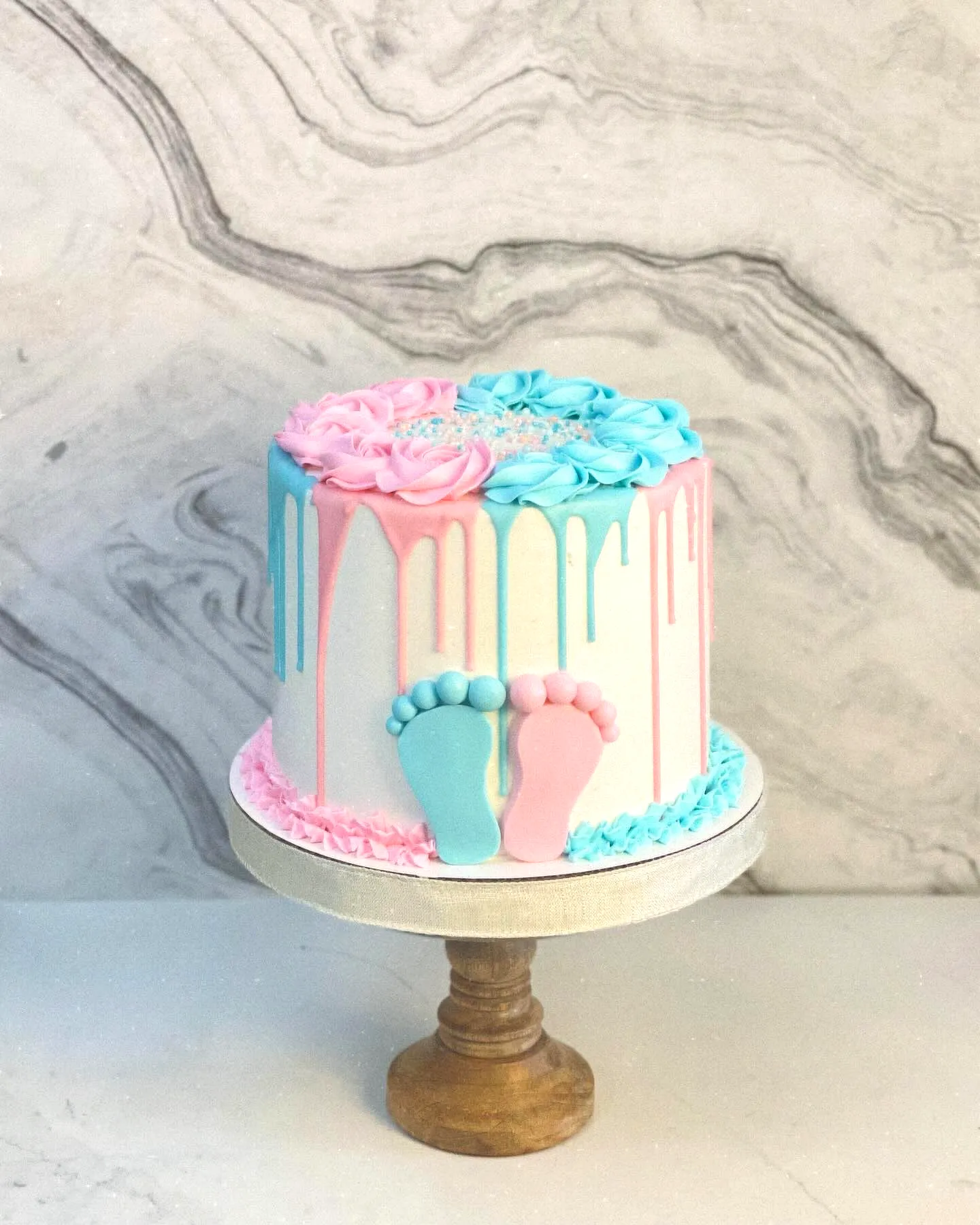 Cute Two-Tiered Gender Reveal Cake with Fun Drip Decor and Rosettes