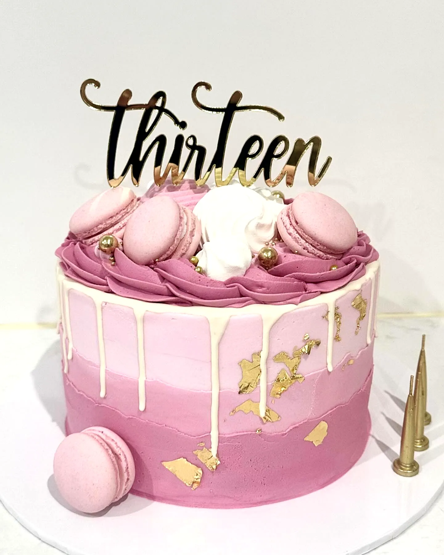 Cute two-tone pink 13th birthday cake with elegant drip and stylish toppings