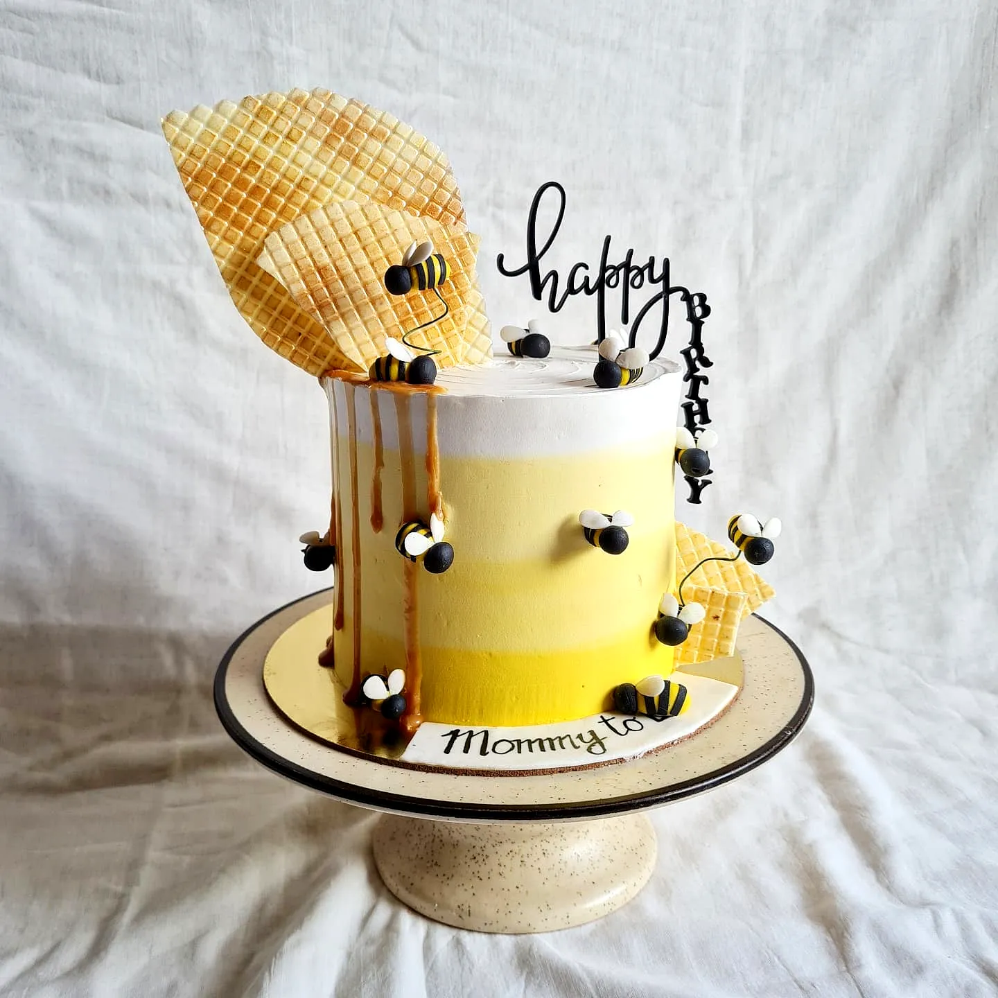 Cute yellow birthday cake design with playful honey-inspired elements