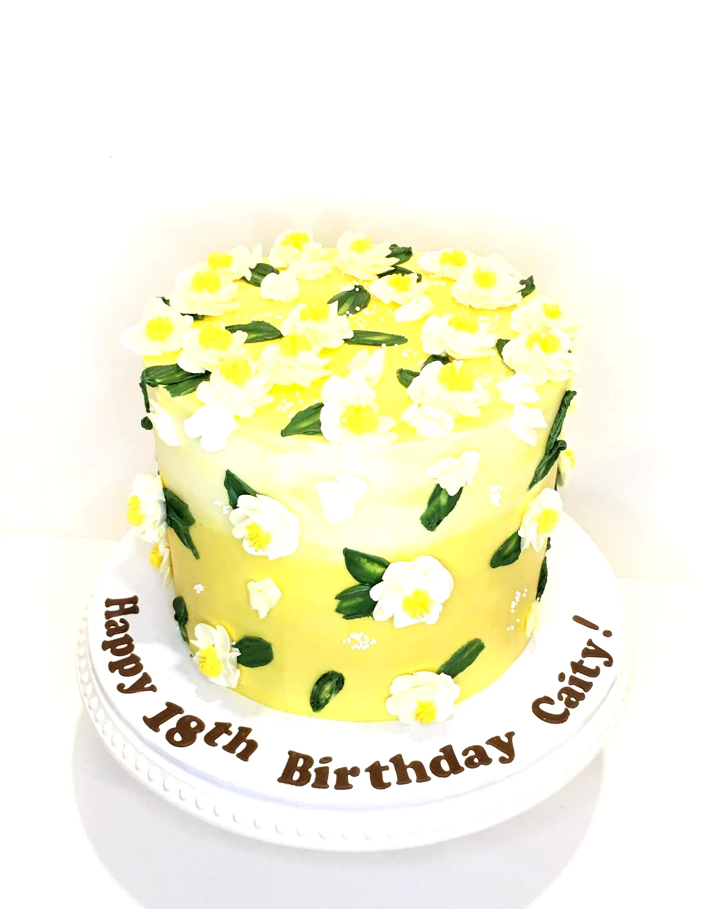 Cute yellow birthday cake design with vibrant decorations and elegant touches