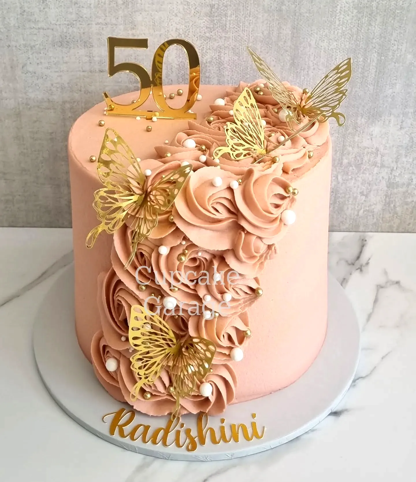 Elegant 50th Birthday Cake in Peach with Beautiful Rosettes and Gold Accents