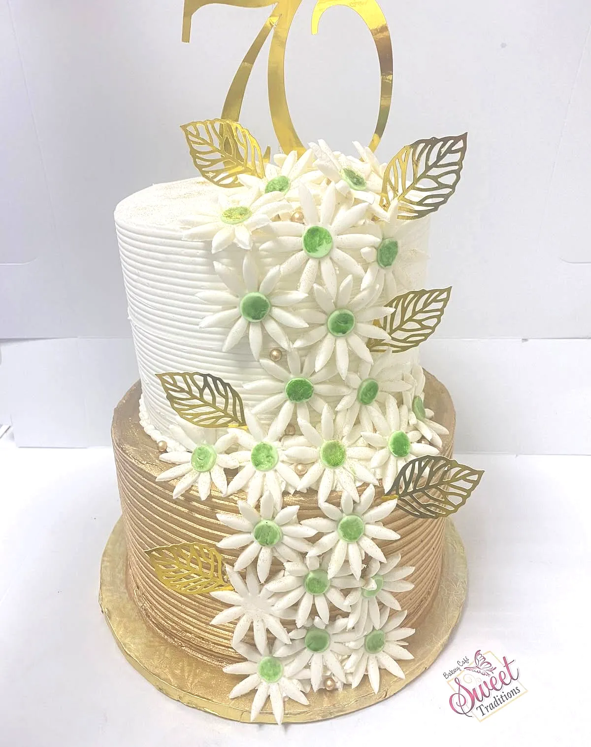 Elegant 70th Birthday Cake Design Featuring Gold Accents and Daisy Decor