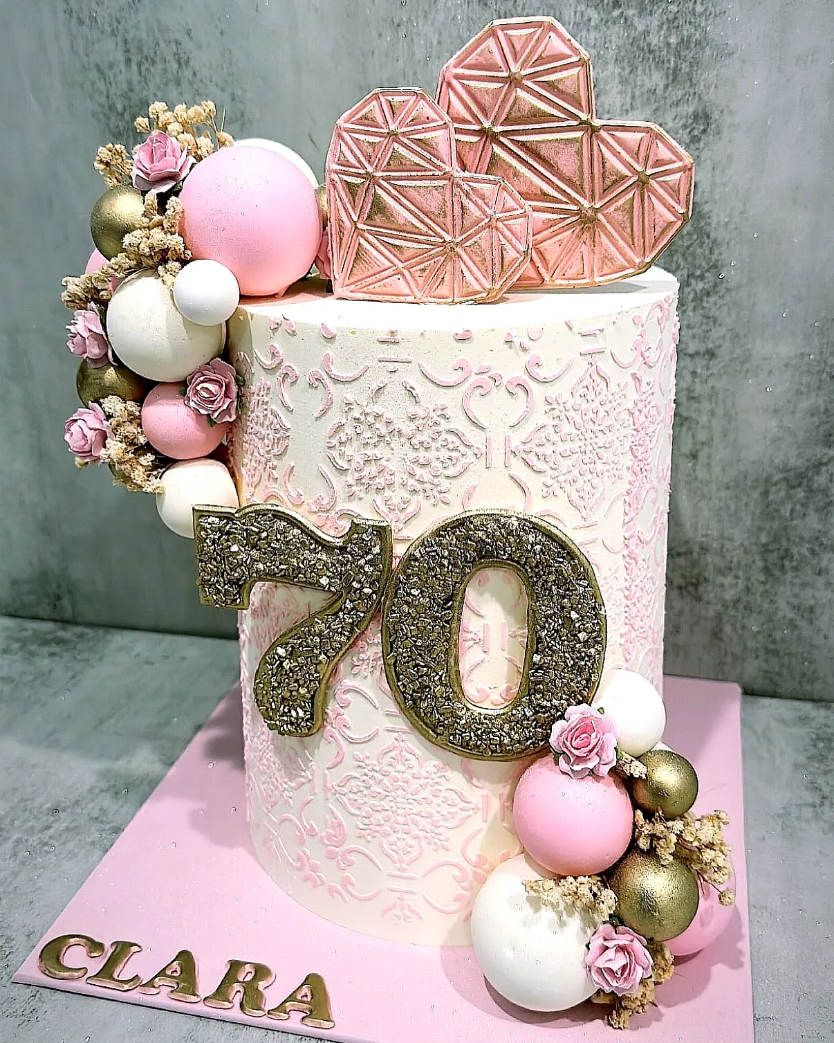 Elegant 70th Birthday Cake with Floral Accents and Glittery Decorations