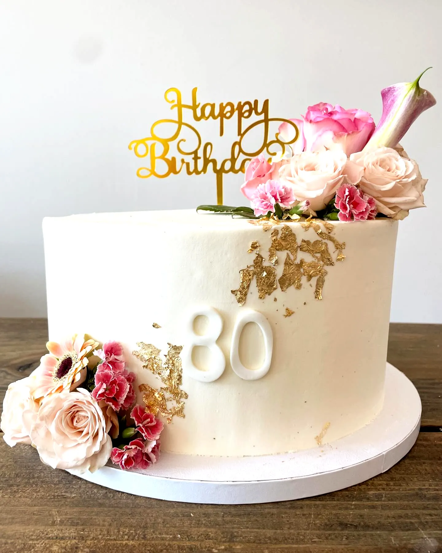 Elegant 80th Birthday Cake Design with Floral Accents and Gold Touches
