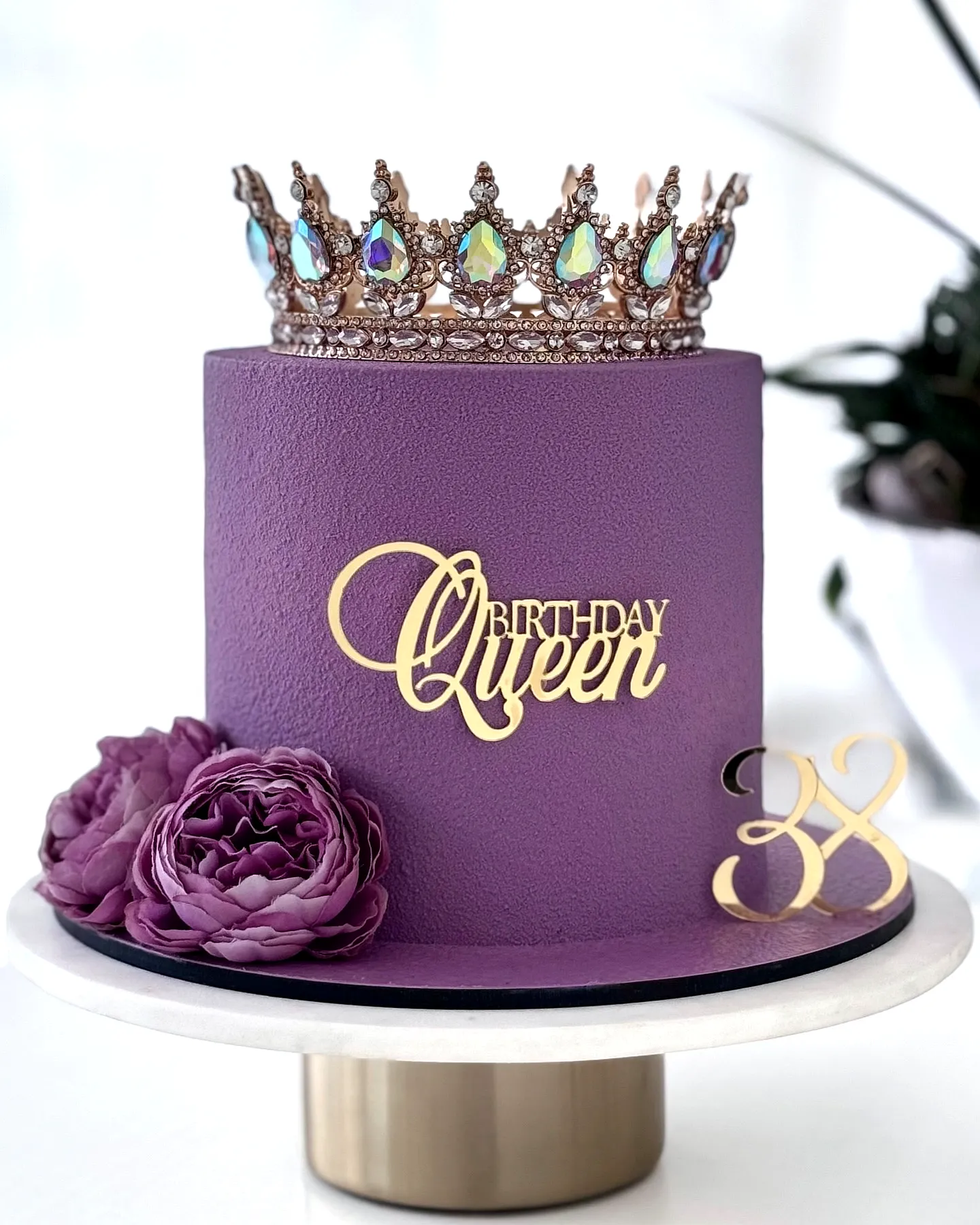 Elegant birthday cake for women with purple finish and sparkling crown