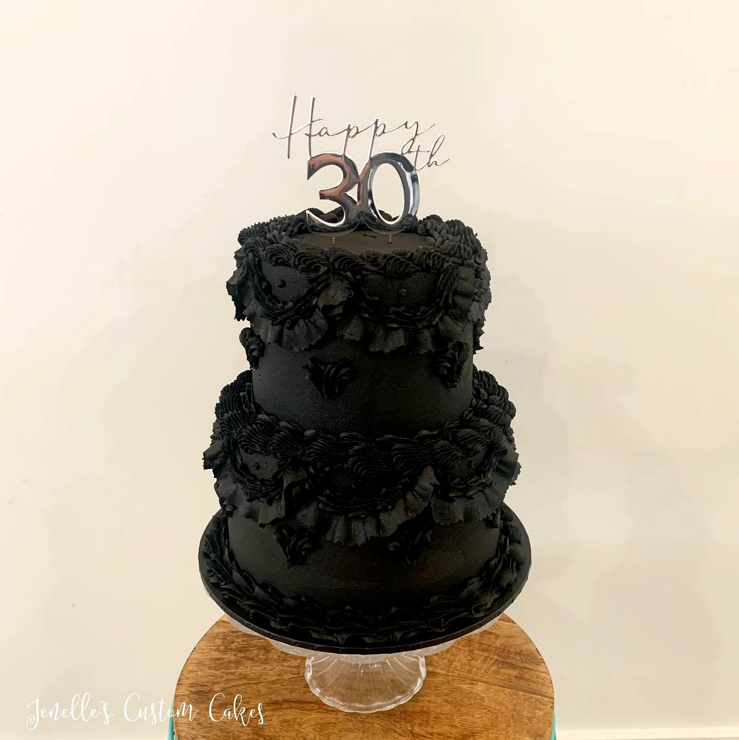 Elegant black velvet 30th birthday cake with rosettes and a sparkling topper