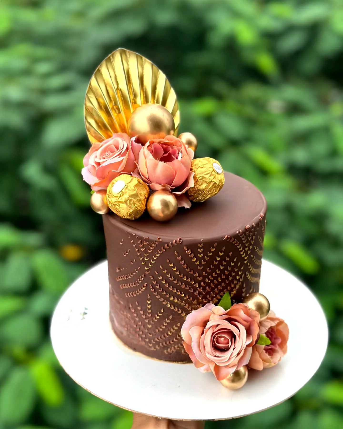 Elegant chocolate birthday cake with ganache and floral decorations